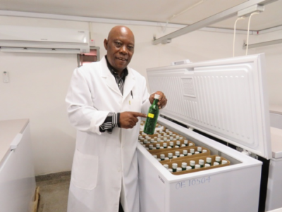 Mr Lerotholi Qhobela holding a glass bottle with seeds.