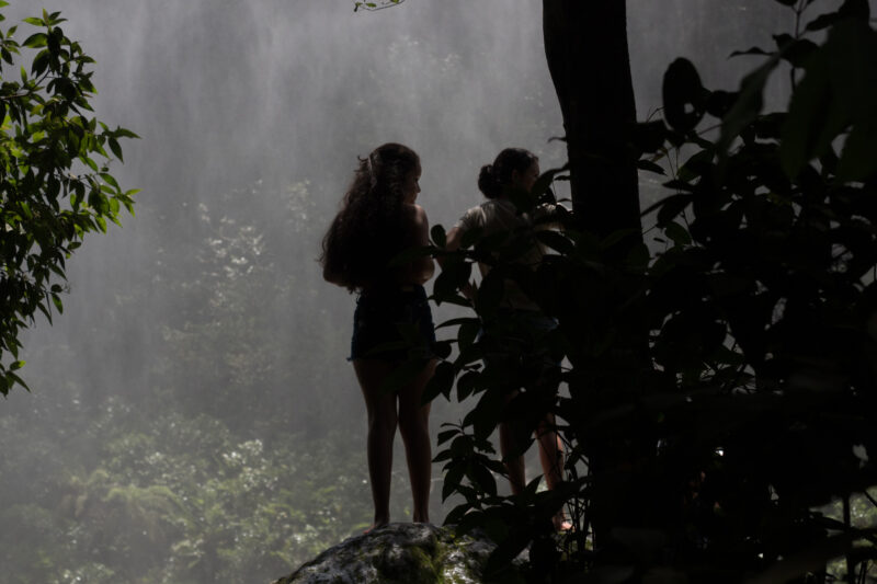 Youg women by waterfall in tropical forest