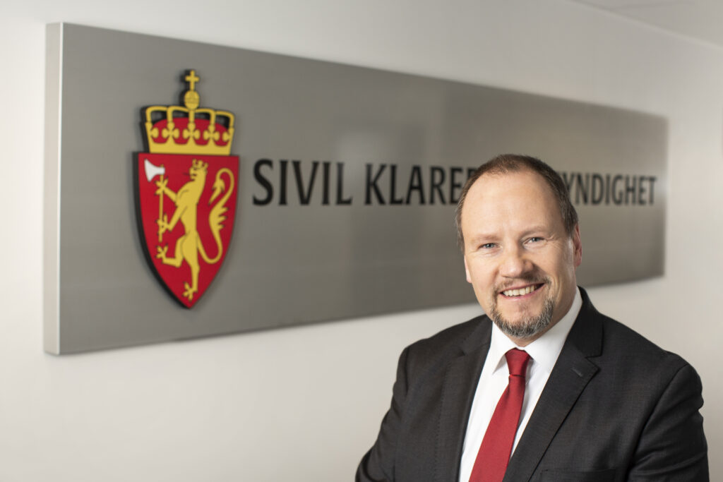 Direktør i SKM Gudmund Gjølstad foran SKM skilt