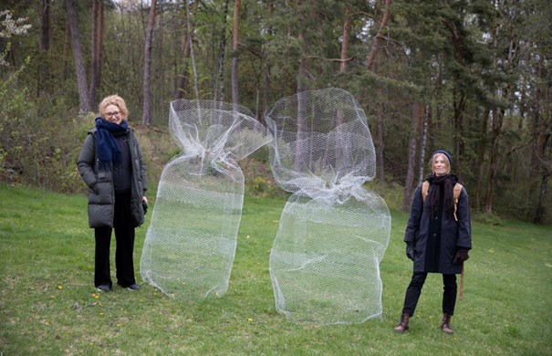 Artists Camilla Dahl and Marielle Kalldal posing next to two wire sculptures.