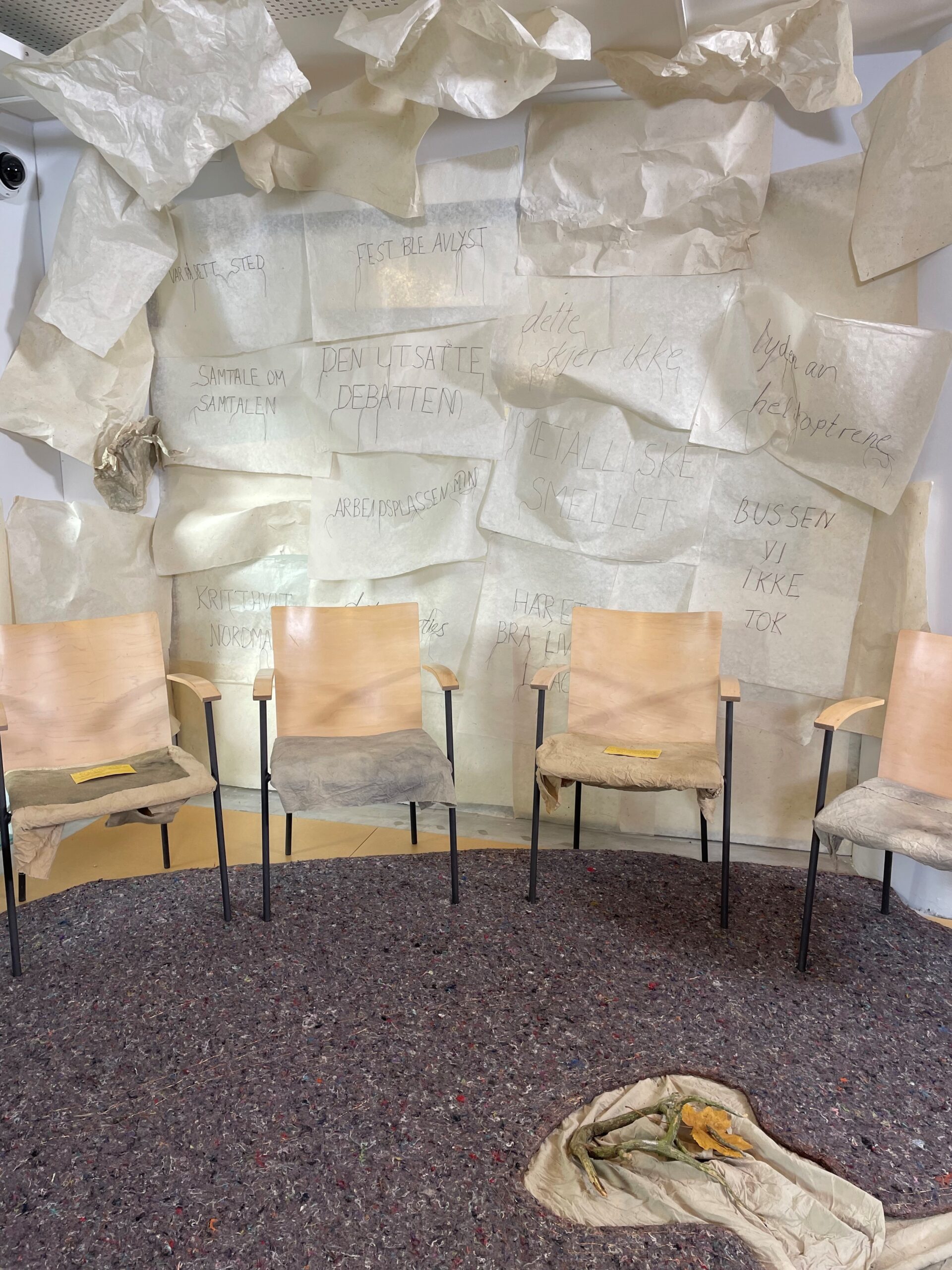 Chairs , rug and embroidered papers forming "Minnering" art installation 