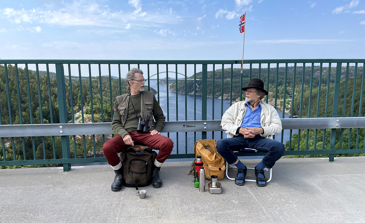 to menn i fluktstoler på hver sin side av grensen på en bro