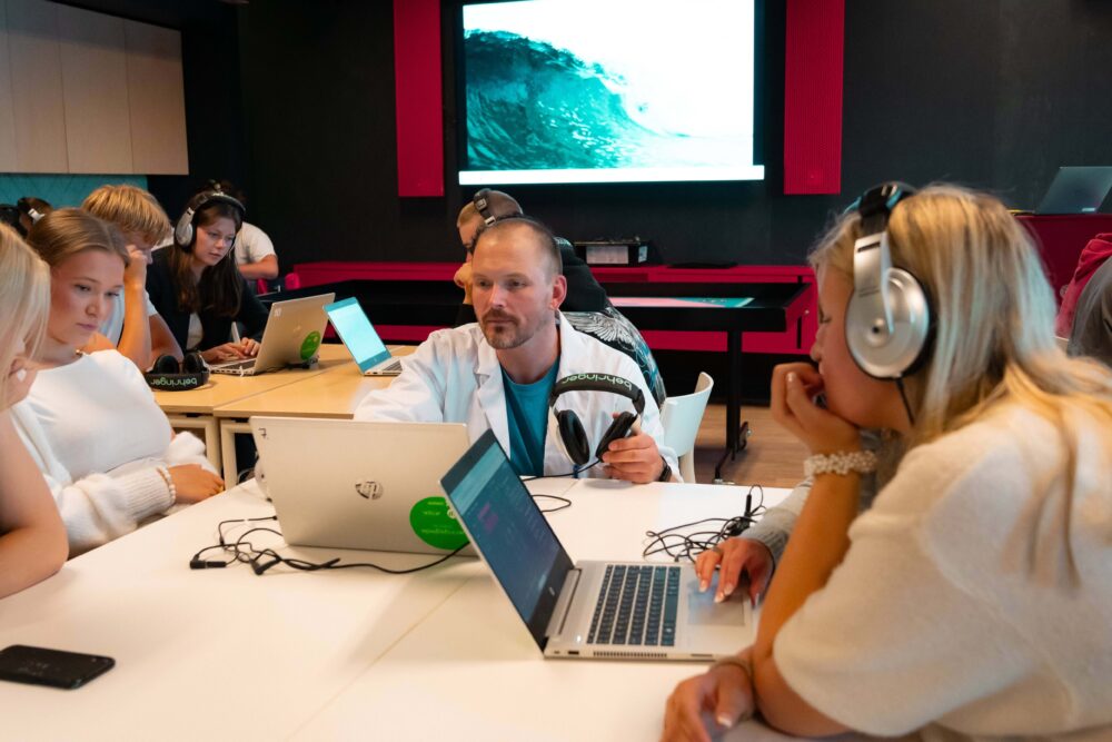 elever som sitter ved pulter og holder på med pc