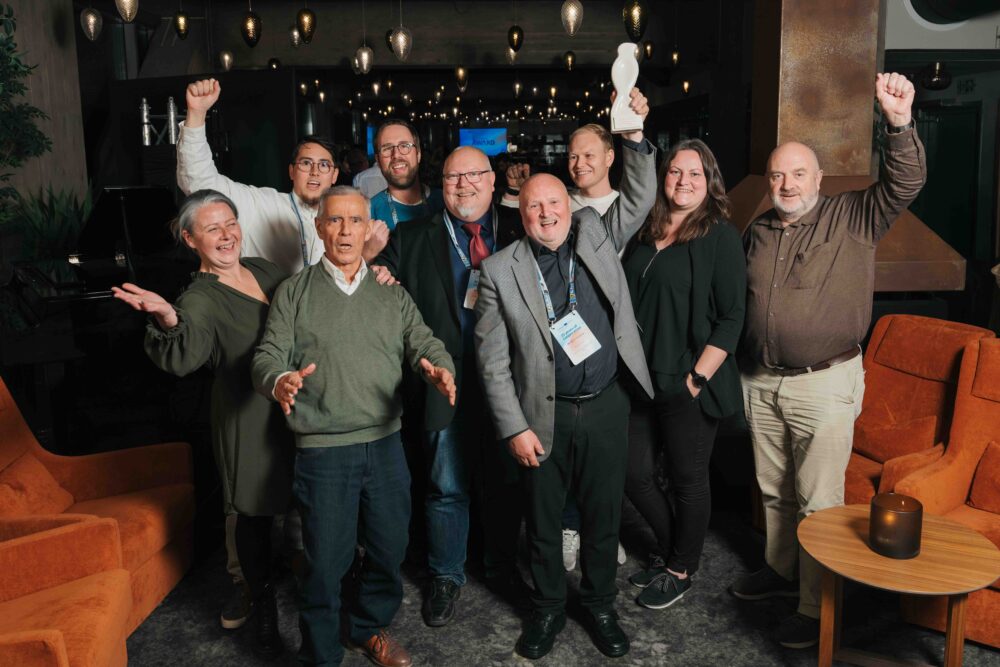 en flokk mennesker som jubler og noen hever hendende 