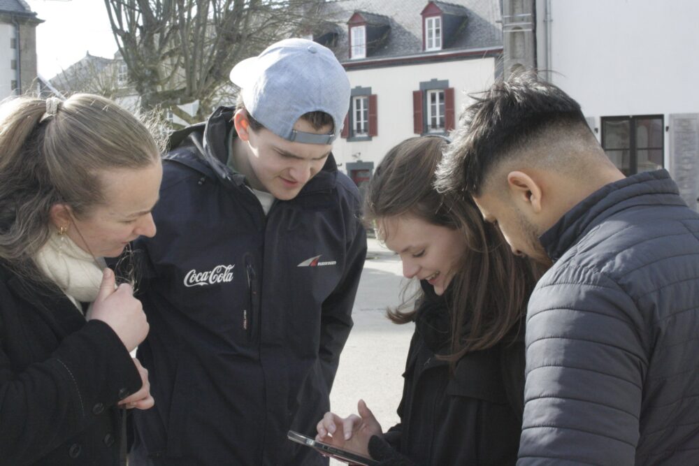 ungdommer som står tet sammen og diskuterer