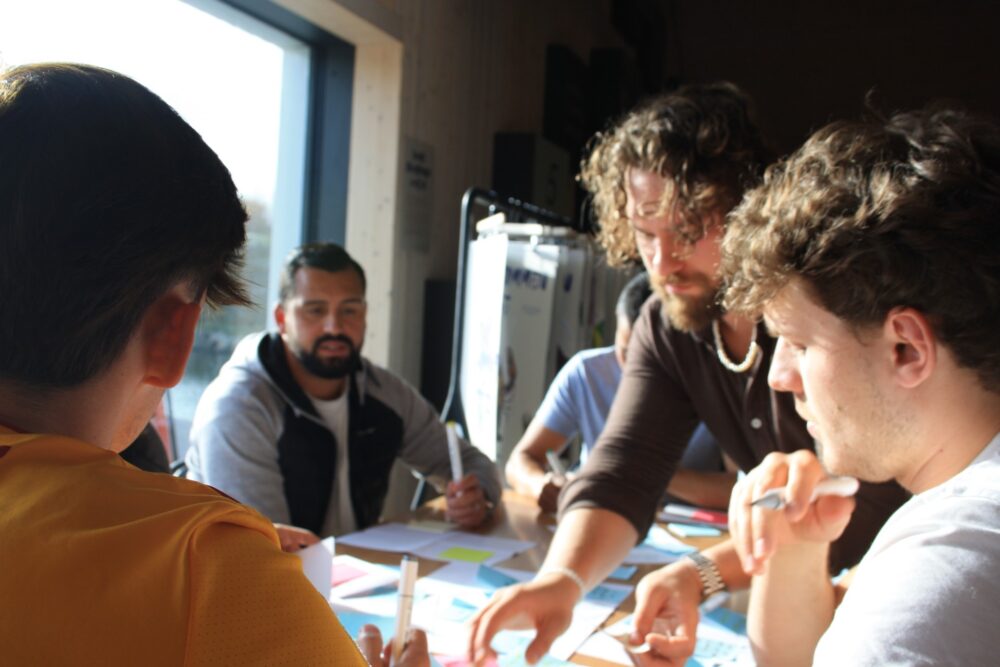 studenter arbeider sammen rundt et bord