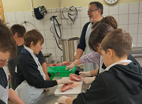 Svein Leiros og Ann-Kristin Hansen lærer elevar å partere og salte lammekjøtt - sjøsamisk kunnskap