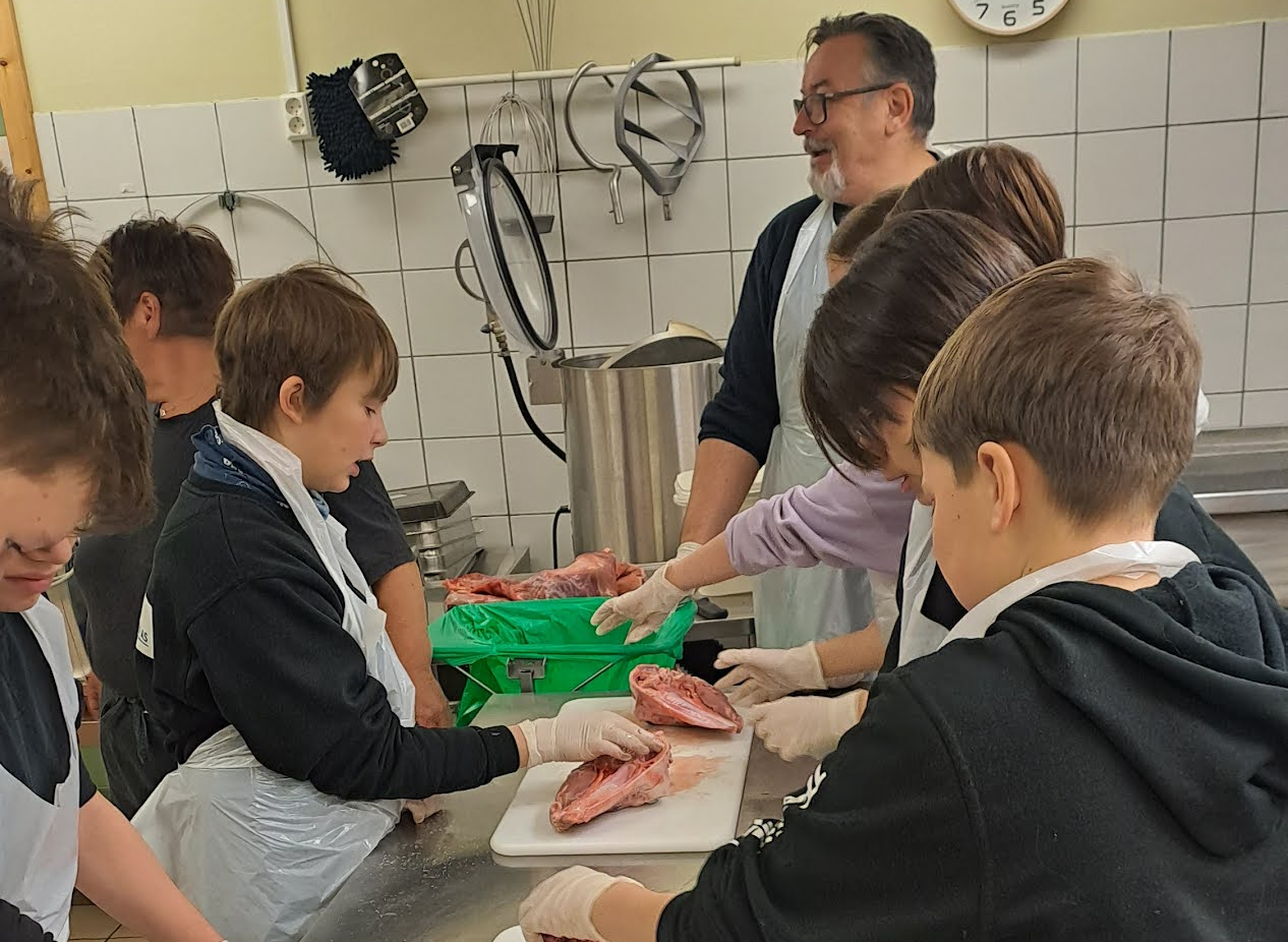 Svein Leiros og Ann-Kristin Hansen lærer elevar å partere og salte lammekjøtt - sjøsamisk kunnskap