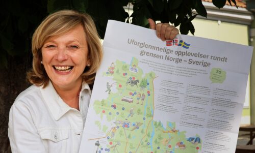 kvinne holder frem et turistkart - reiseliv i grenseregionen