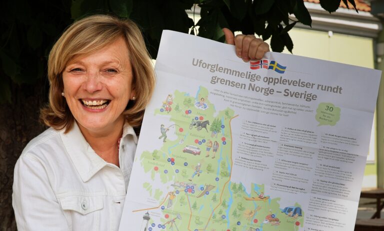 kvinne holder frem et turistkart - reiseliv i grenseregionen