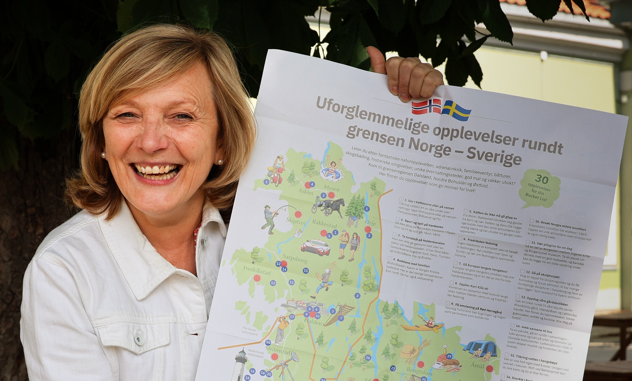 kvinne holder frem et turistkart - reiseliv i grenseregionen