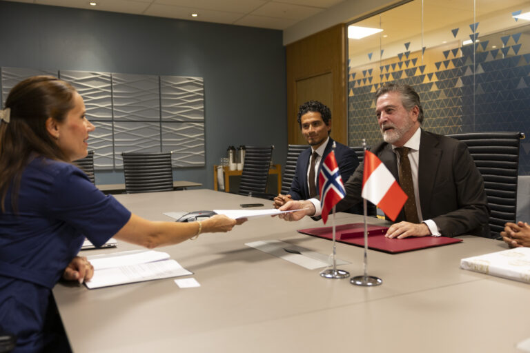 Peru's Ambassador Gustavo Laurie Escandón handing the signed declaration to Norwegian Minster of Fisheries, Marianne Sivertsen Næss. Next to the ambassador is Julio Antonio Ubillús, Deputy Chief of Mission at the Peru Embassy in Norway