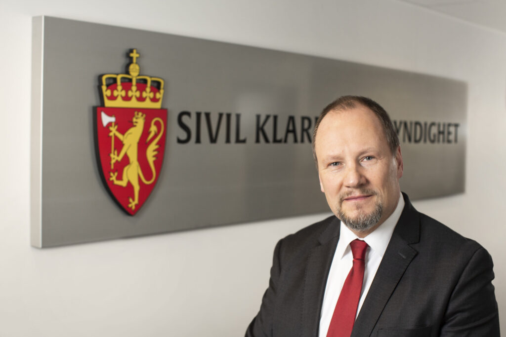 Direktør i SKM Gudmund Gjølstad foran SKM skilt