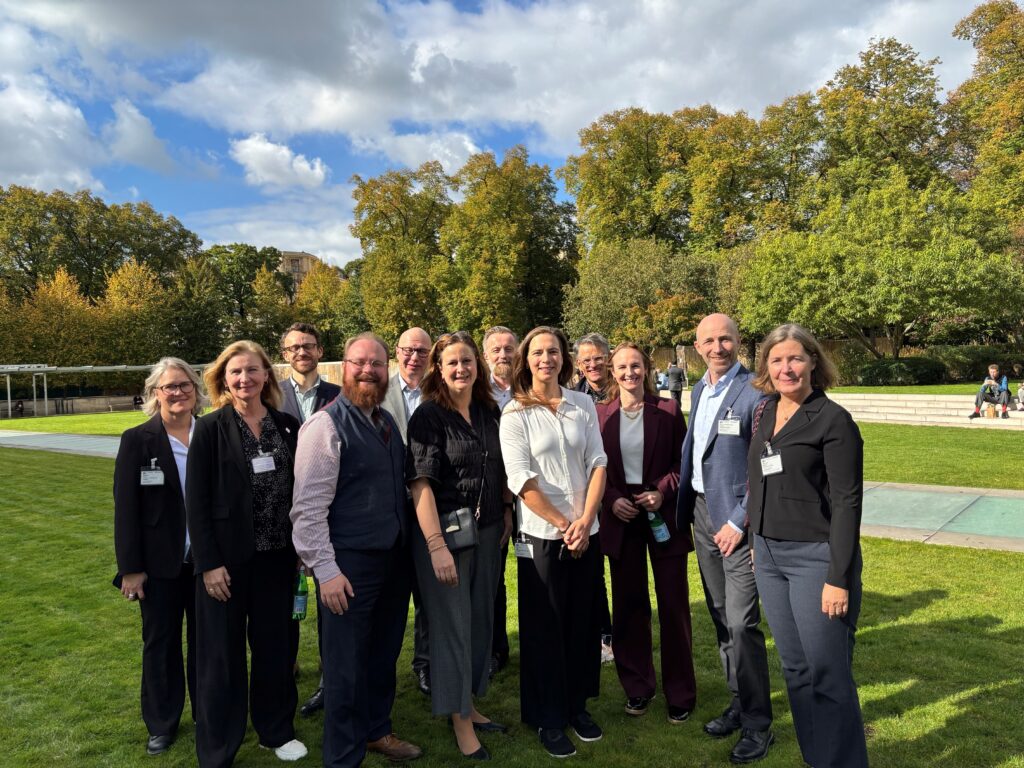 Utvalg og sekretariat i gården til OECD-hovedkvarteret.
