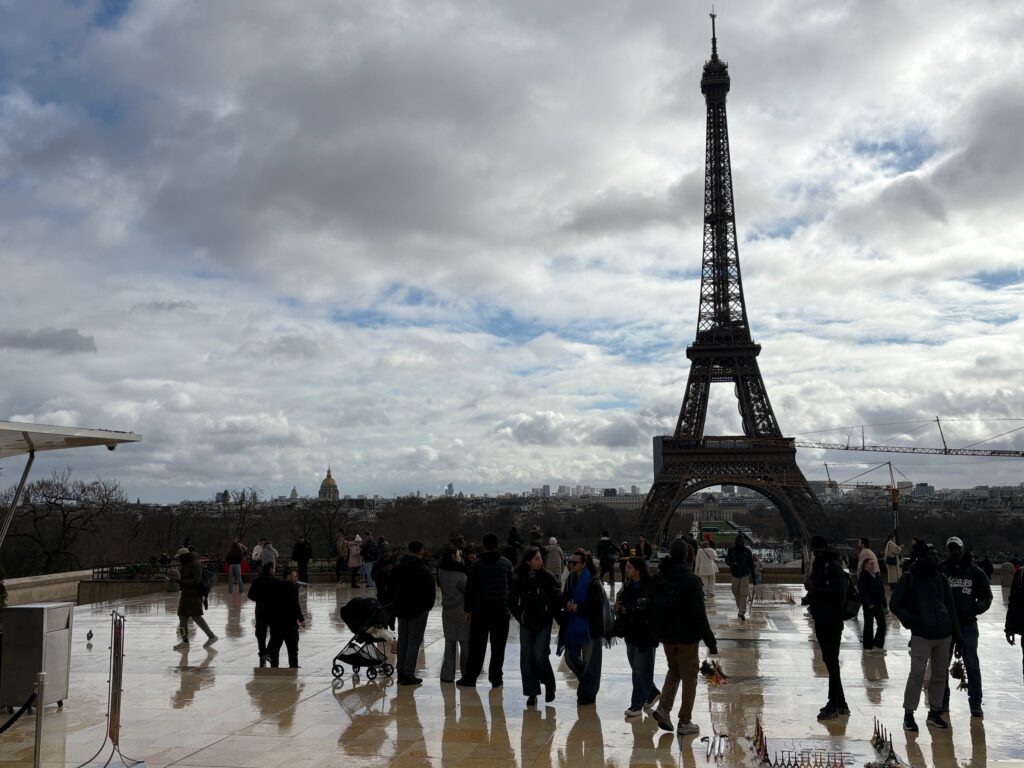 Eiffeltårnet i silhuett med en rekke personer i forkant.