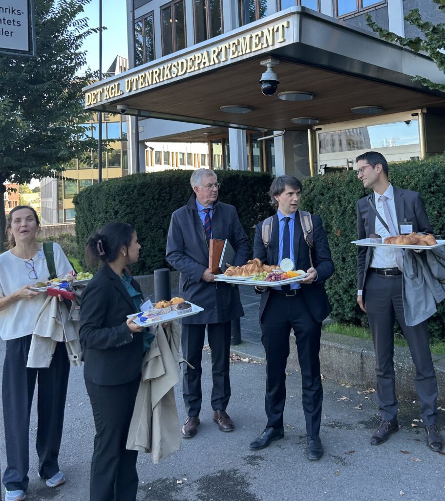 Tre menn og to kvinner utenfor Utenriksdepartementet tar med restemat til neste møte